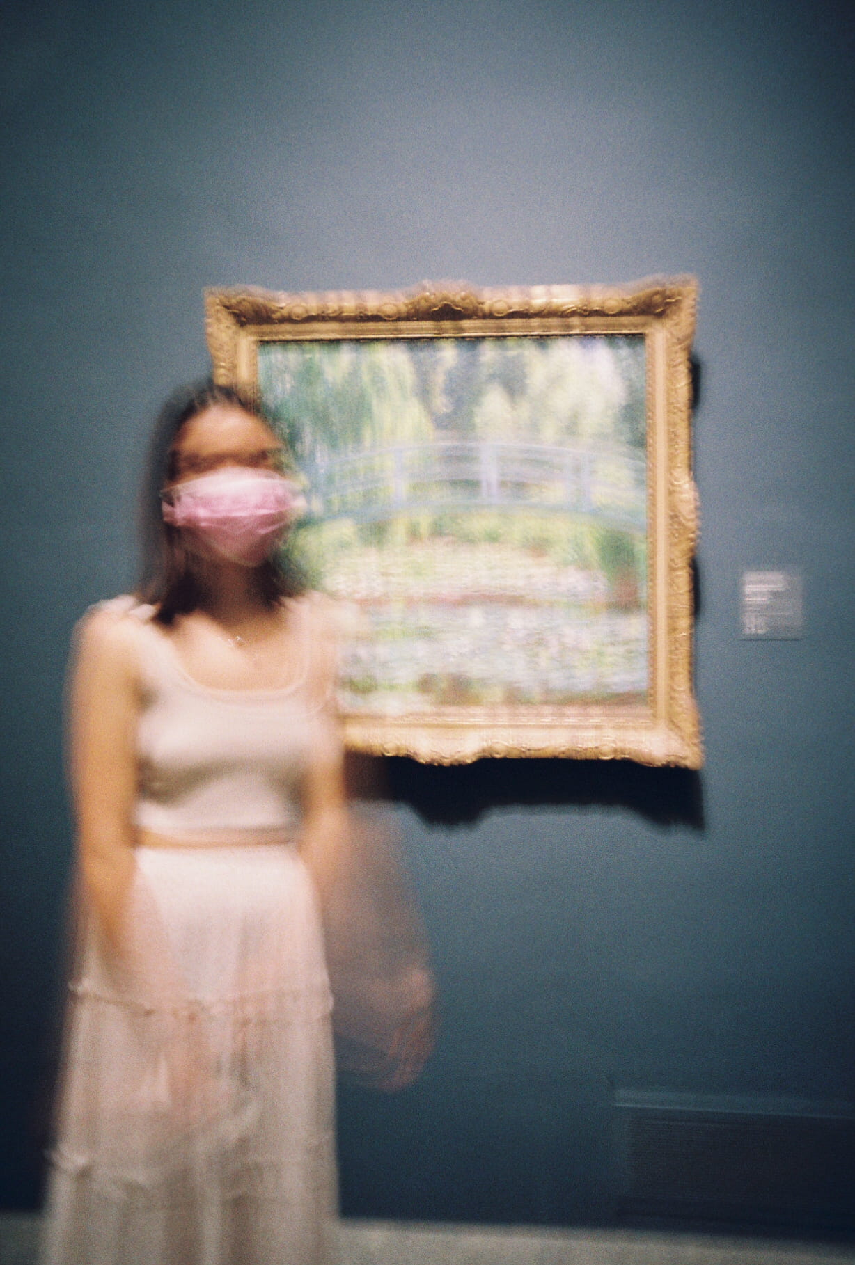 blurred image of girl standing in front of framed picture